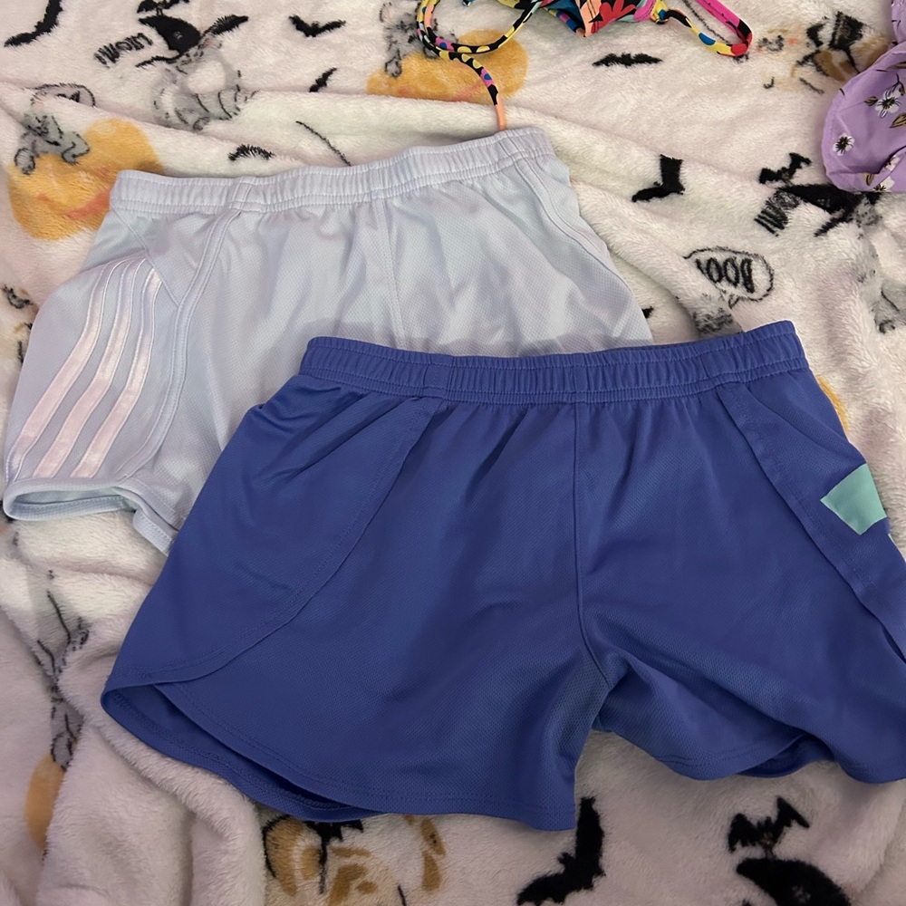 Two pairs of girls medium Adidas dolphin athletic shorts.